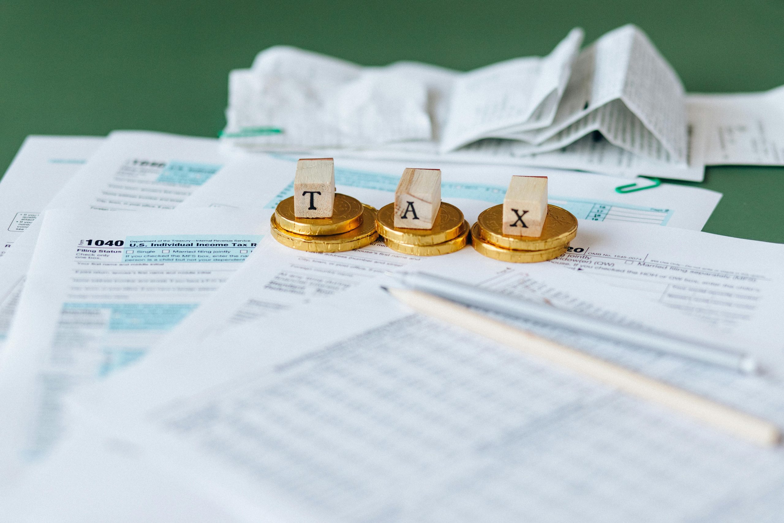 A cluttered desk with IRS forms and a calculator highlighting frustration during tax season