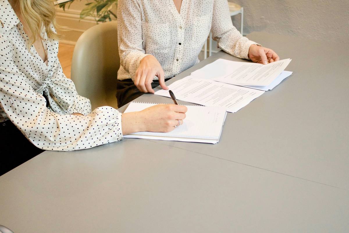A person consulting with their tax strategy mentor while reviewing documents.